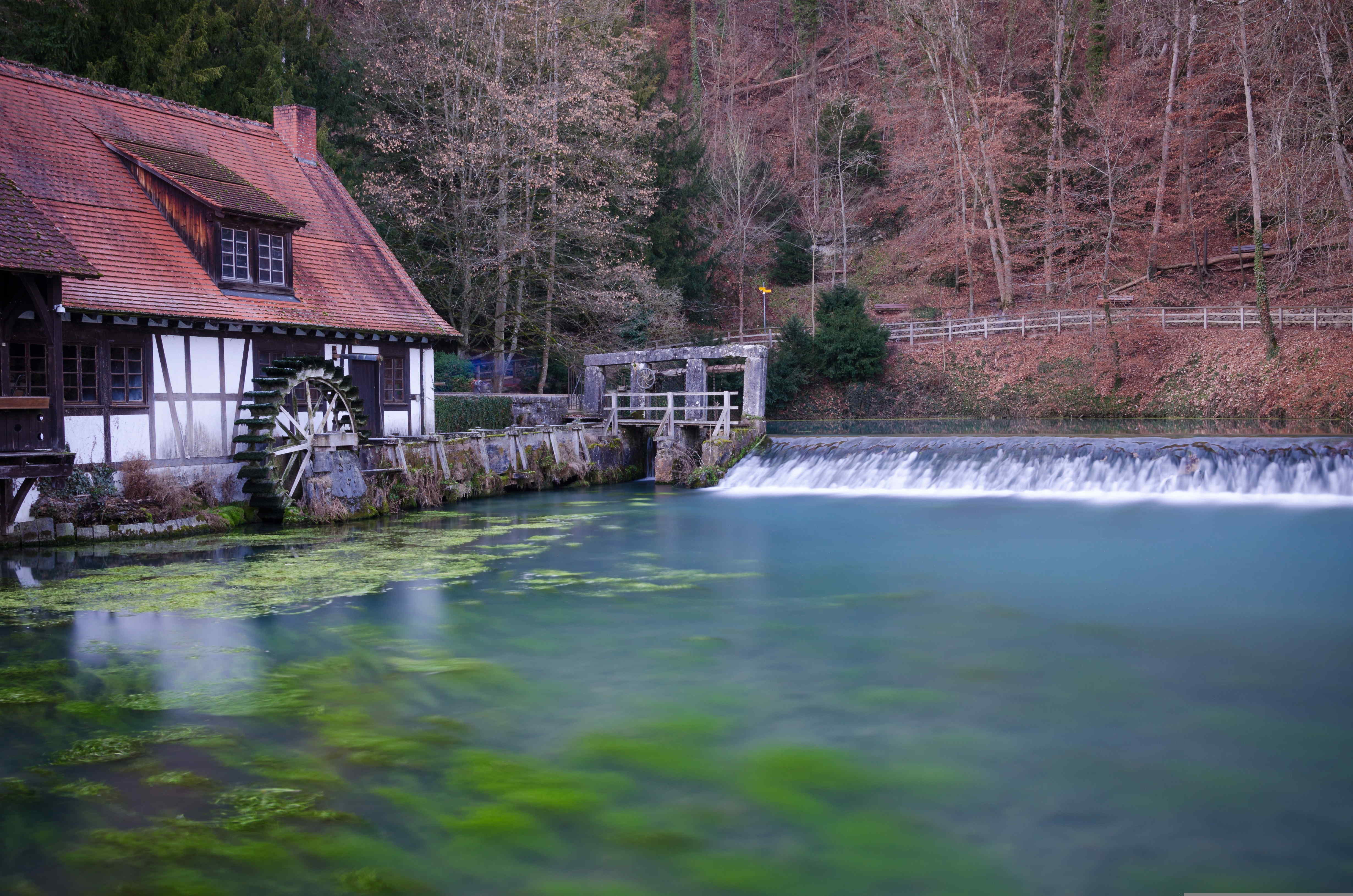 Blautopf bei Blaubeuren Blautopf bei Blaubeuren mit historischem Gebäude und bewaldeter Umgebung