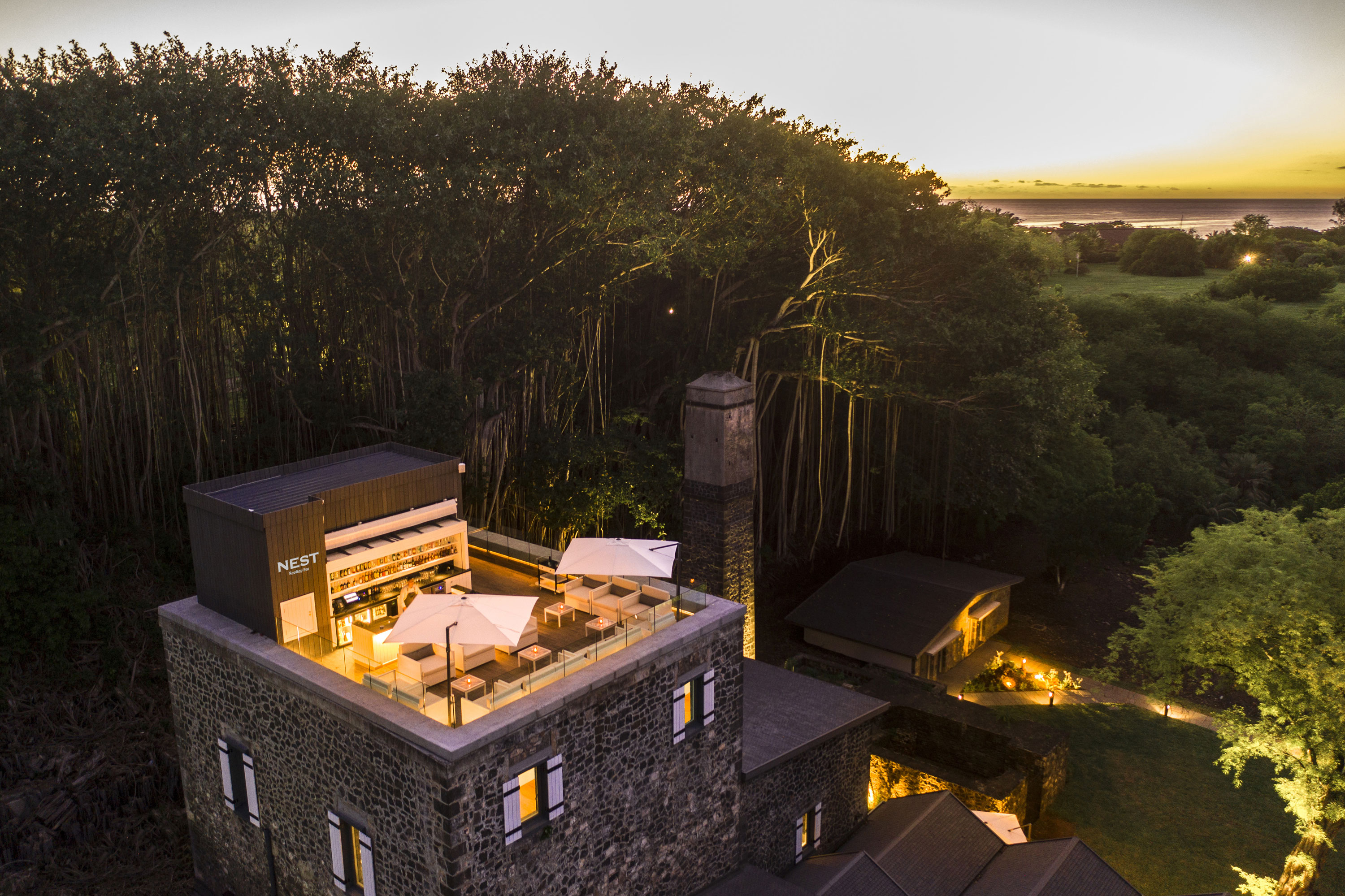 Eventlocation "The Nest" Eine stilvolle Dachterrasse des Hotels mit bequemen Sitzmöglichkeiten und einer atemberaubenden Aussicht bei Sonnenuntergang