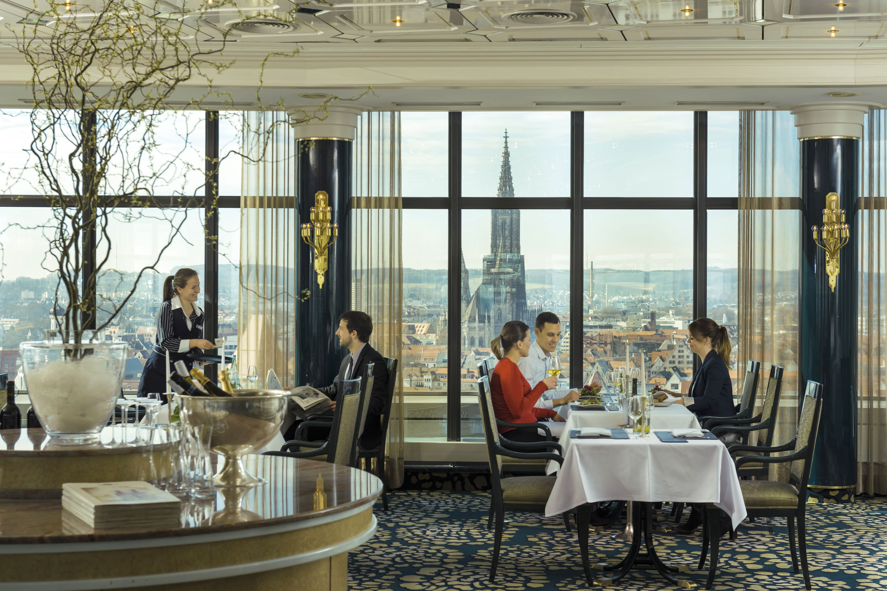 Gäste genießen das Essen mit Blick auf das Ulmer Münster im Panorama-Restaurant des Maritim Hotel Ulm